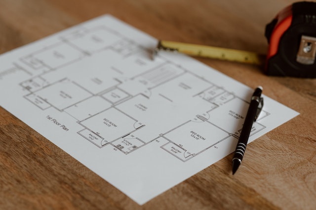 rental property blueprint on a table with pen and measuring tape