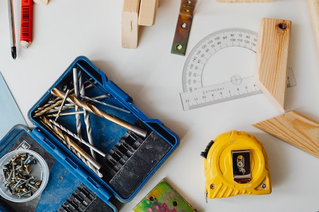 toolbox with nails and screws and measuring tap on a table